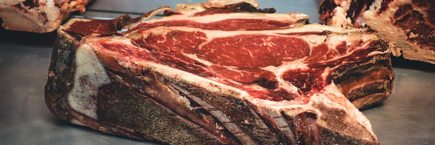 Proceso de maduración de carne mostrando cortes de carne en distintas etapas de maduración para resaltar la mejora en sabor y textura